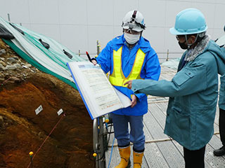 敷地内断層について説明を受ける有馬さん（右）